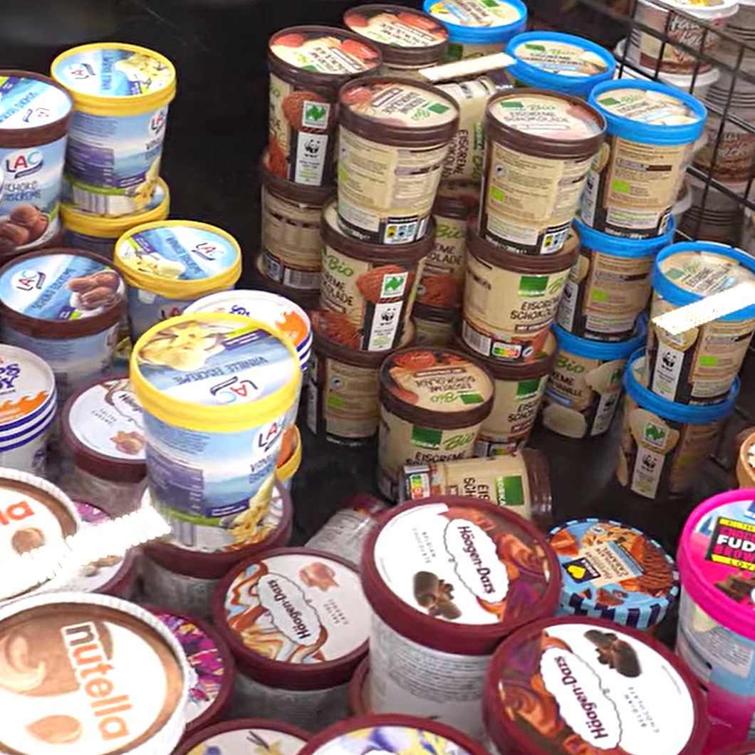 Chest freezer with ice cream cups buried and out of reach — disorganized, no lift system