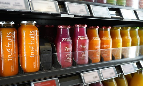 POS-T Vincent Universal Pusher System installed on retail gondola shelf with products uniformly front-facing